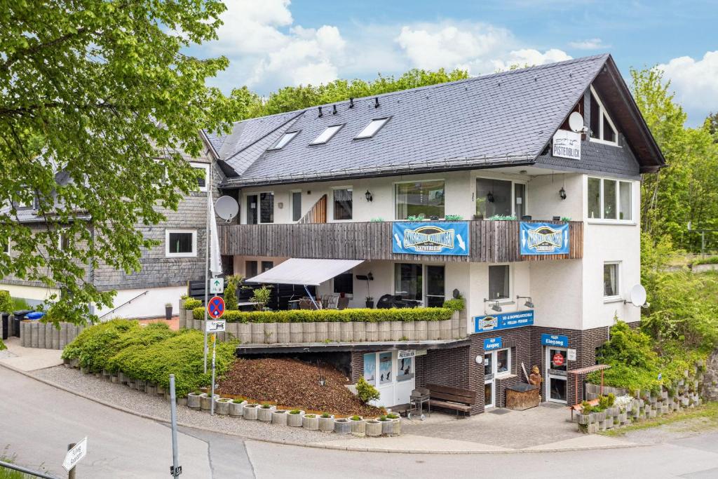 a large white building with a black roof at Pistenblick in Willingen