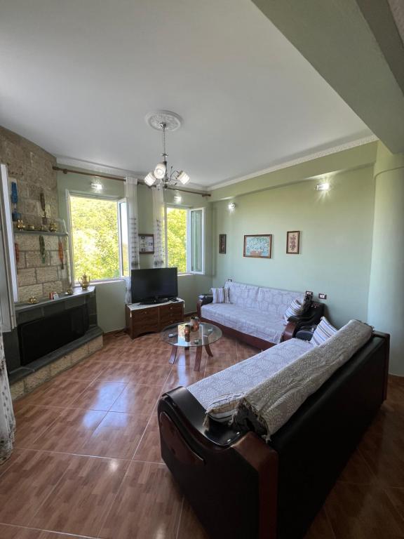 a living room with a couch and a tv at Selim Guesthouse 2 in Lybeshë