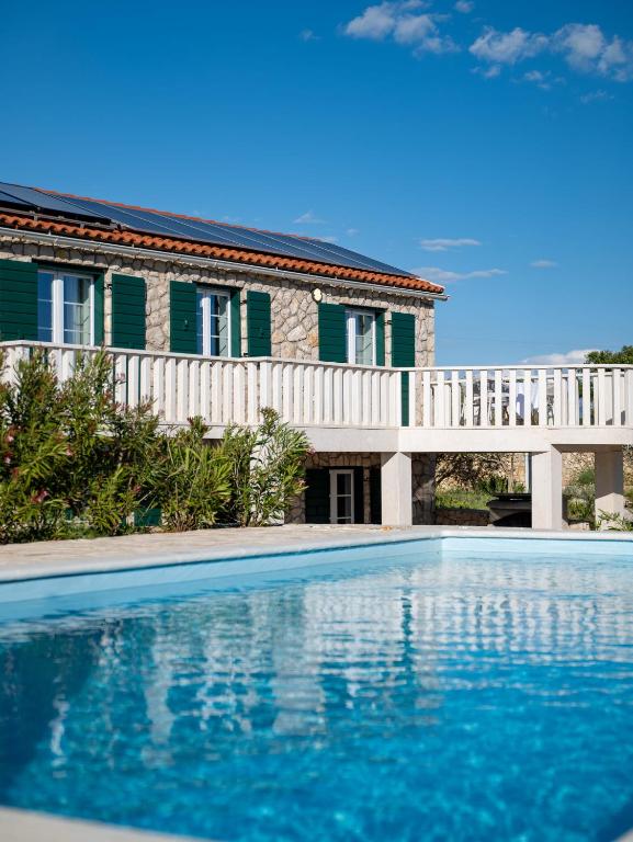 a swimming pool in front of a house at Villa Maslina in Novalja