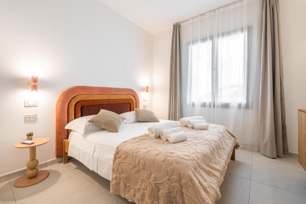 a bedroom with a bed with towels on it at Domus Luxi in Teulada