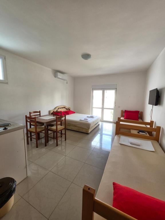 a room with a bed and a table and chairs at Apartmani Viki in Sutomore
