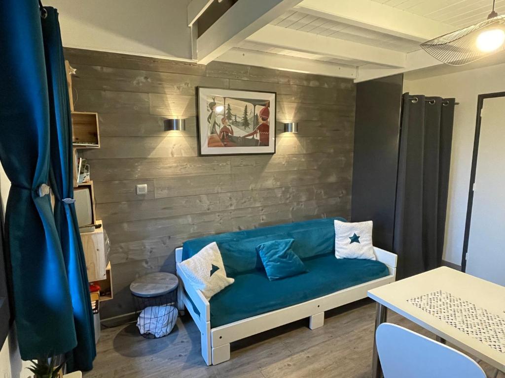 a living room with a blue couch in a room at La Louvatière 28 in Mijoux
