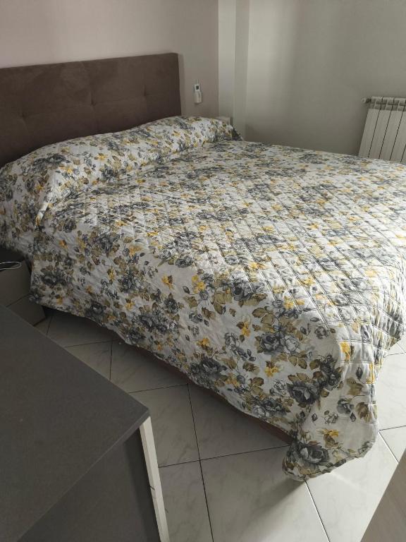a bed with a floral comforter in a bedroom at Cibali rooms in Catania