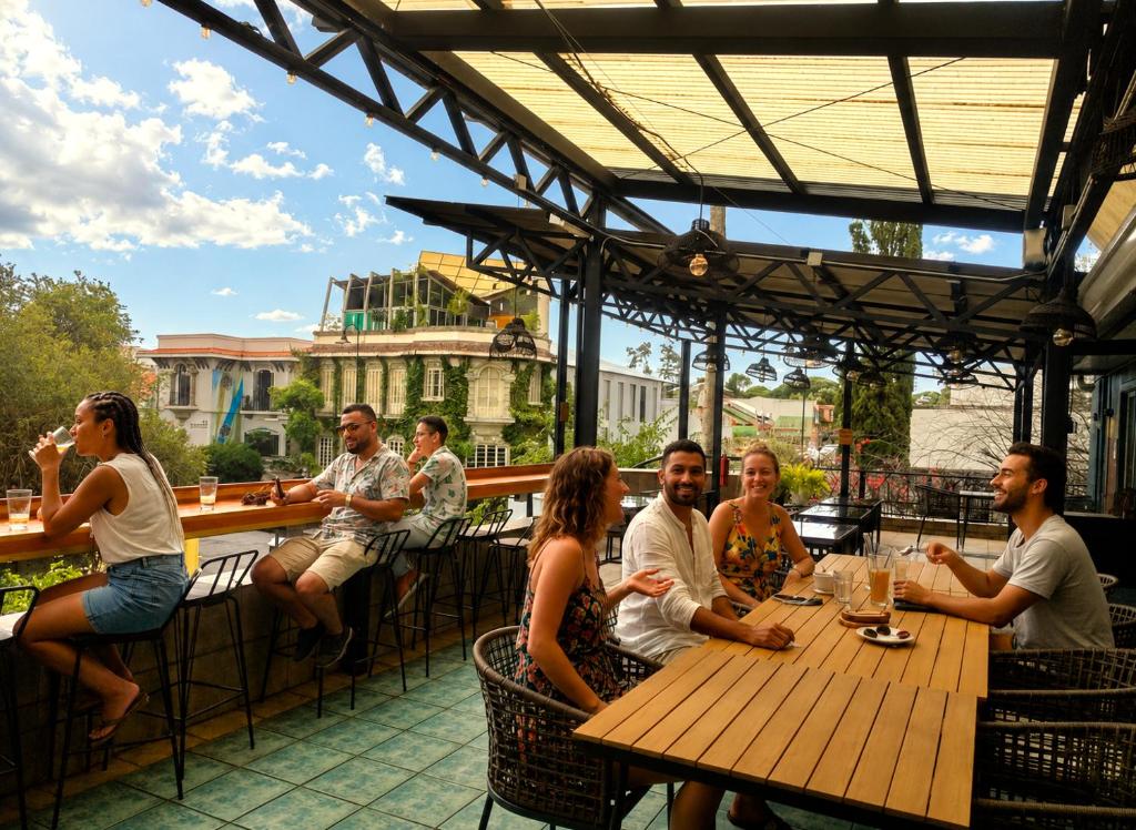 a group of people sitting around a wooden table at Viajero San José Hostel in San José