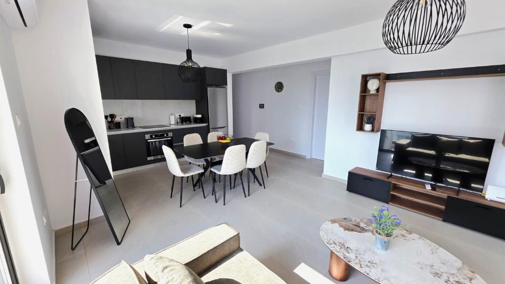 a living room and kitchen with a table and chairs at Spacious & Modern - Best Larnaca Location in Larnaca
