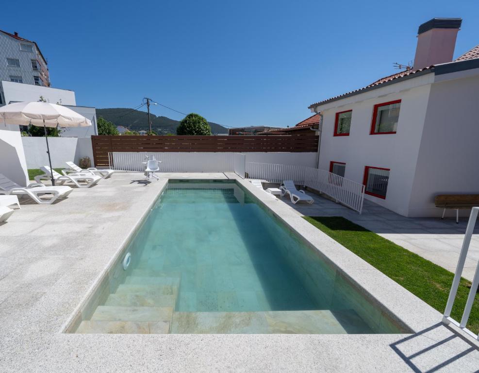 a swimming pool in the backyard of a house at Apartamentos turísticos O Estaleiro in Moaña