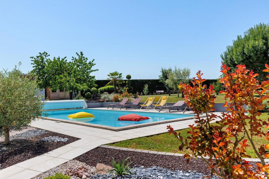 a swimming pool with colorful pillows in a yard at Chambre d'Hote Familiale in Neuville-du-Poitou