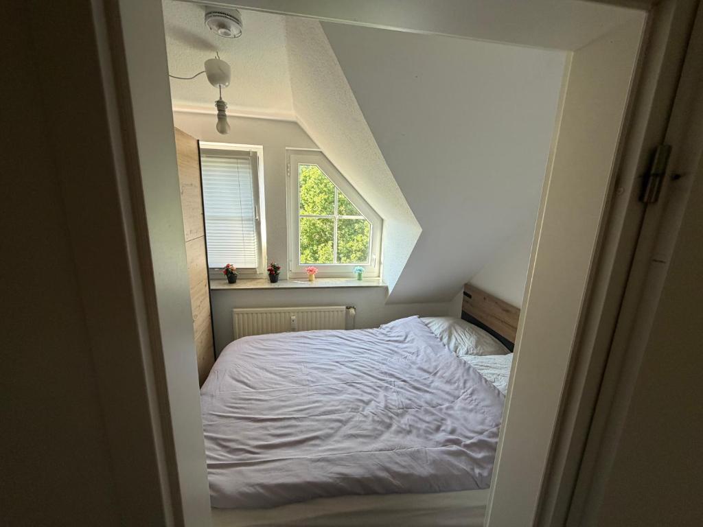 a small bedroom with a bed with a window at Modernes gemütliches Studio Zimmer in Elmshorn