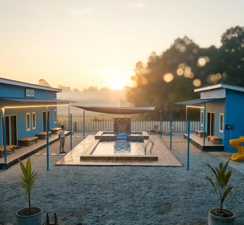 a person standing in front of a house with a fountain at D'Biru Guest Room in Melur