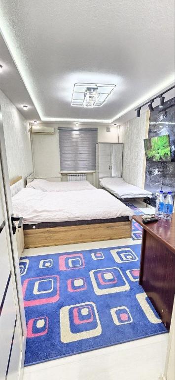 a bedroom with a bed and a blue rug on the floor at ARZON Halal Hotel in Tashkent