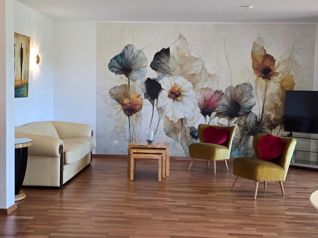 a living room with a painting of flowers on the wall at Exklusive Ferienwohnung Bad Salzschlirf - direkt am Waldrand - großer Garten kompett umzäunt - Hunde willkommen - 2 private Stellplätze in Bad Salzschlirf