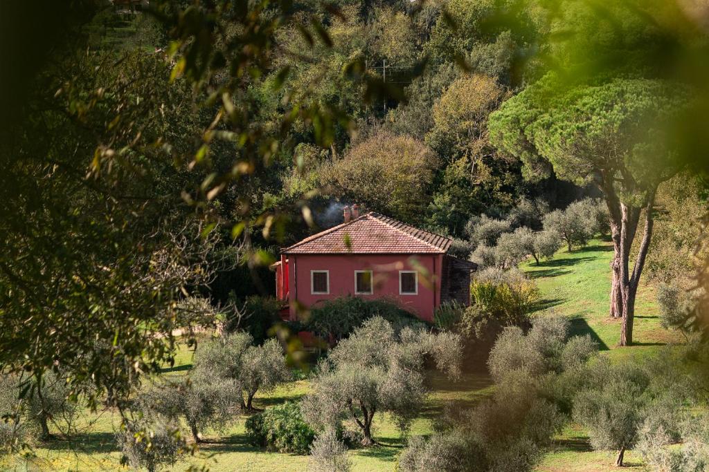 a red house in the middle of a field with trees at Villa Flavia in Manziana