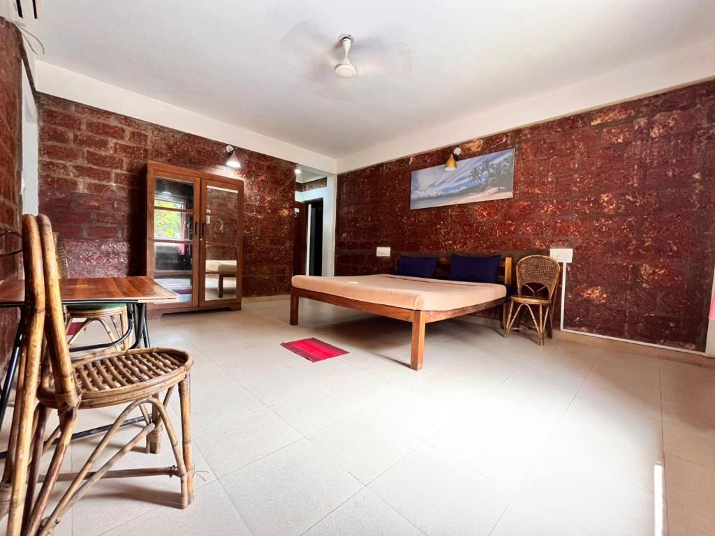 a room with a table and chairs and a brick wall at Casa Viora in Calangute