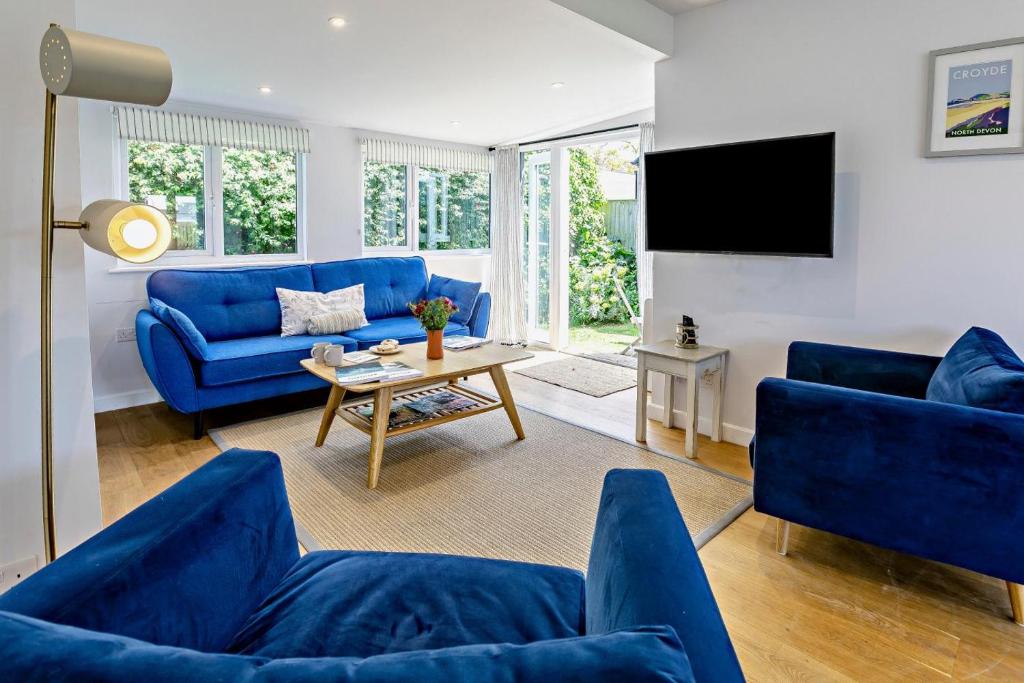 a living room with blue couches and a tv at 2 Bed in Croyde oc-18lead in Croyde