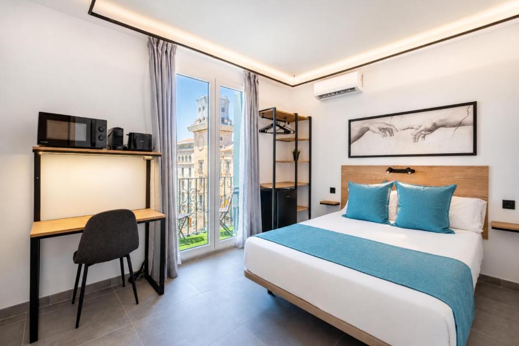 a bedroom with a bed and a desk and a window at White Coast Suites in Alicante