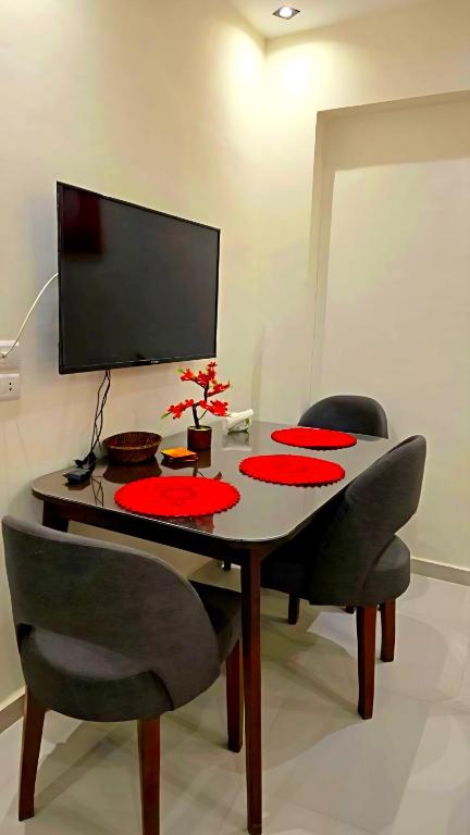a dining room table with chairs and a computer monitor at Solara in Hurghada