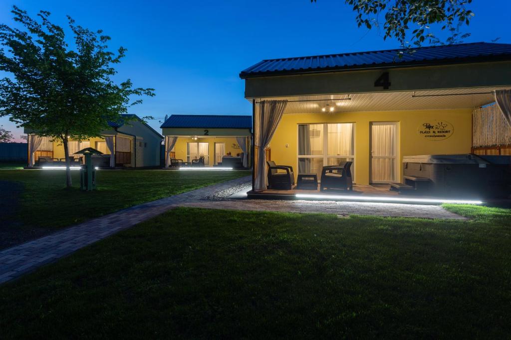 a house with a patio at night with lights at Pájer Plázs & Resort in Gyomaendrőd