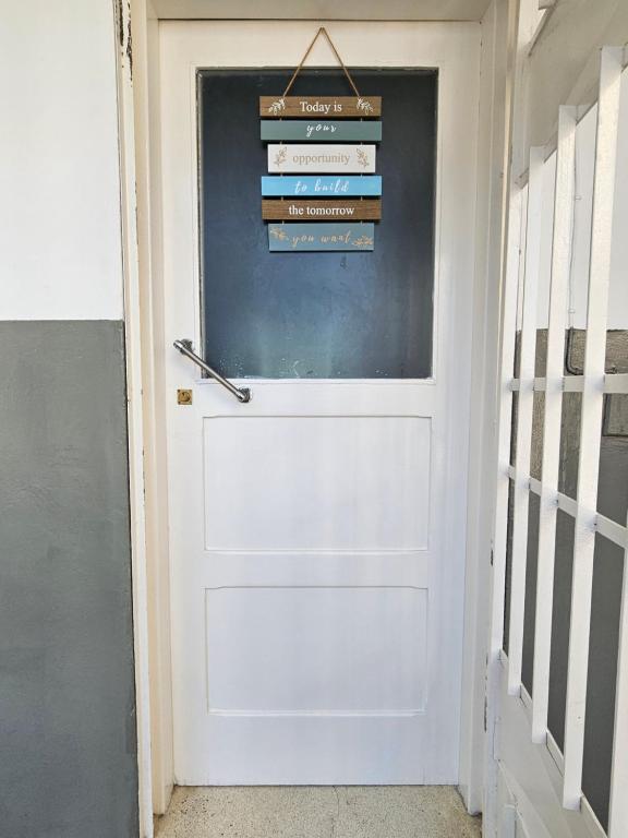 a white door with a sign on it at Luxury Comfort House in Maputo