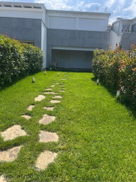 a grass yard with stepping stones in front of a building at Maiullari Holiday House in Policoro