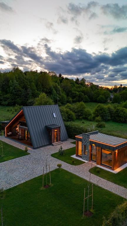 a house with a gambrel roof on a field at Luxury Aframe in Râşnov