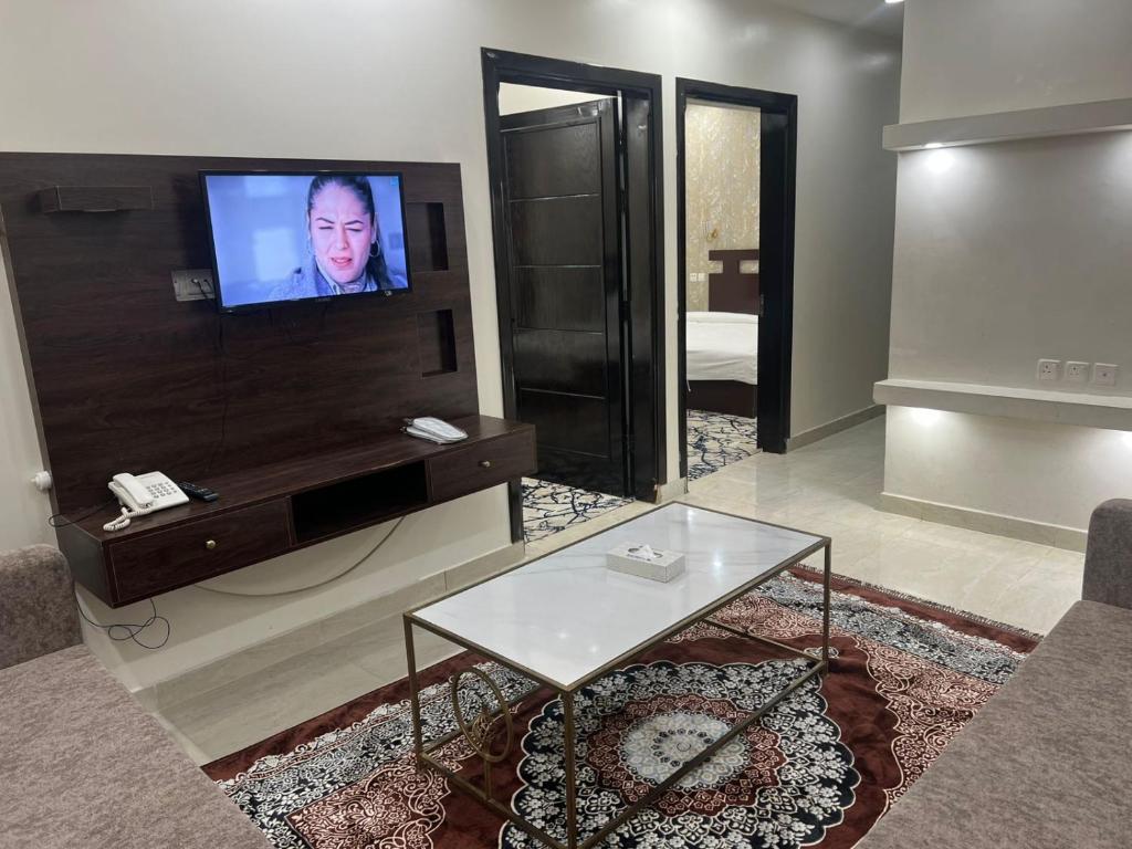 a living room with a flat screen tv on a wall at منتصف البيعة للشقق المخدومة in Taif