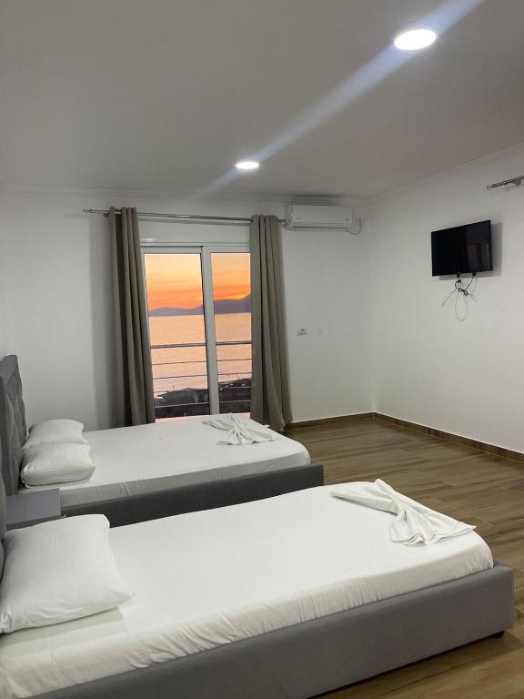 two beds in a room with a view of the ocean at Aria Apartments in Borsh