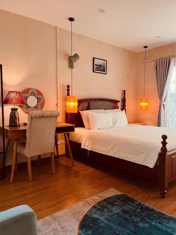 a bedroom with a large bed and a desk and a chair at Tranquility Stay Old Quarter in Hanoi