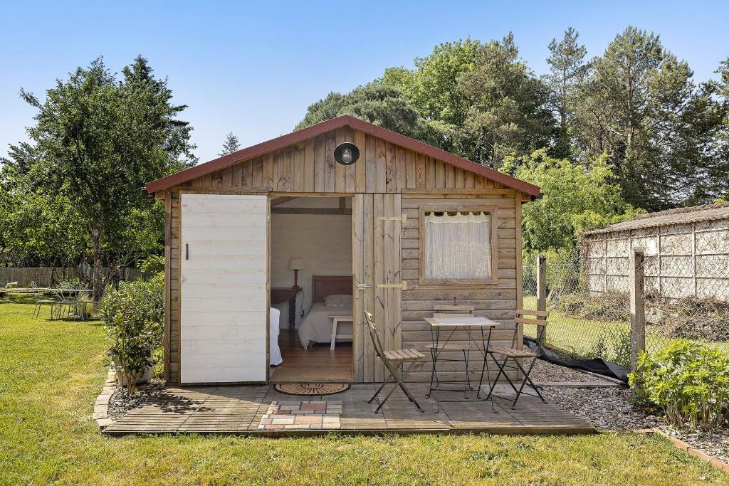 a wooden shed with a table in a yard at Chalet La Bienvenue in Vouzon