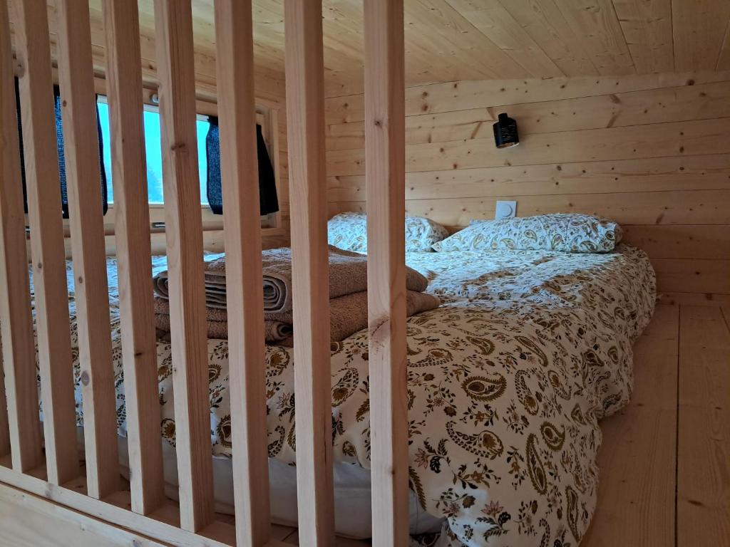 a bedroom with a bed in a wooden cabin at Tiny Mélisse in Leimbach