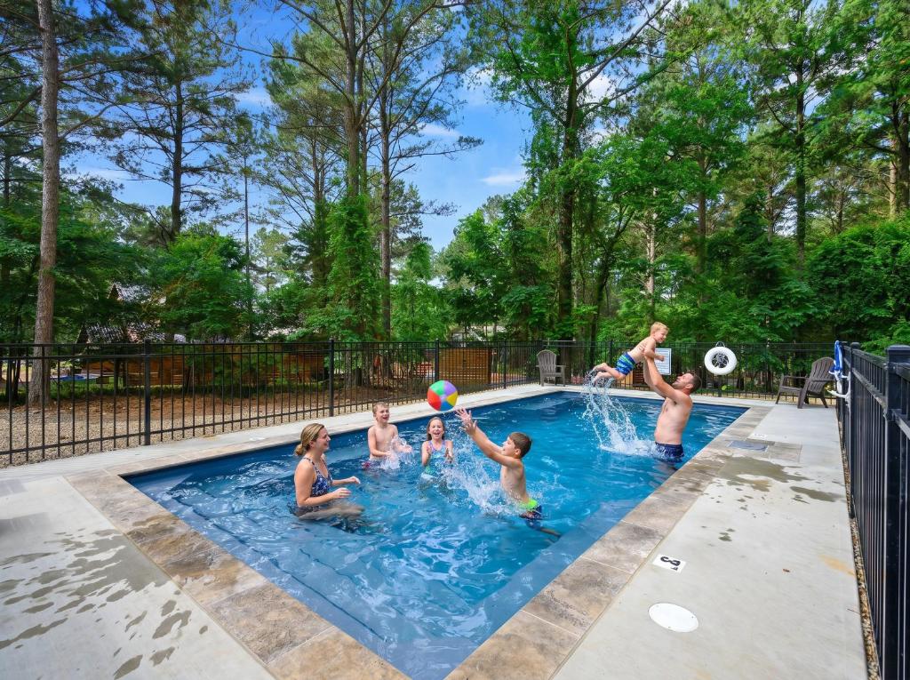 a group of people playing with a ball in a swimming pool at Fireside in Broken Bow