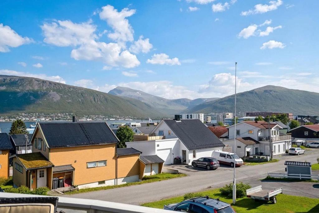 a suburb with houses and mountains in the background at Modern Arctic Apartment in Tromsø