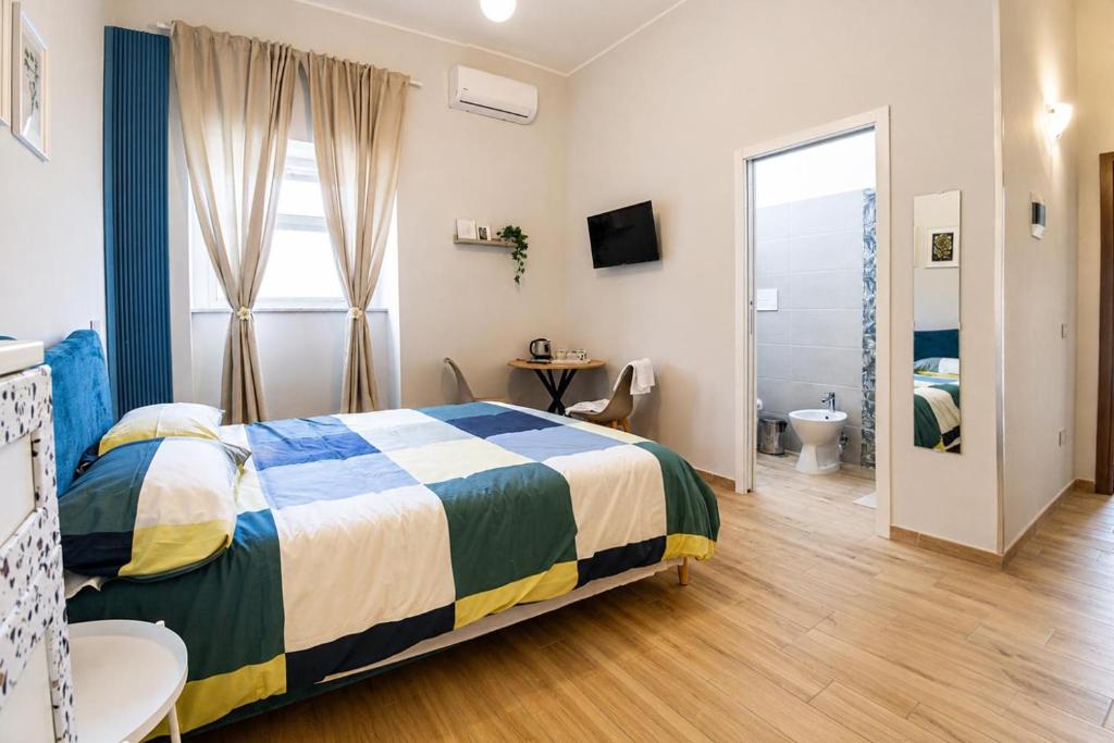 a bedroom with a bed and a desk and a window at Fuoribinario B&B in San Felice a Cancello