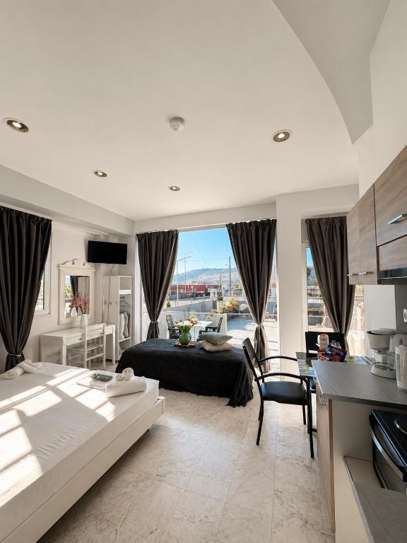 a bedroom with a bed and a table and a kitchen at Nova marine 5 in Souda