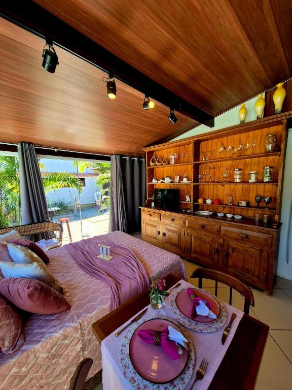 a bedroom with a bed and a table with plates on it at Luz Residence suíte in Cabo Frio