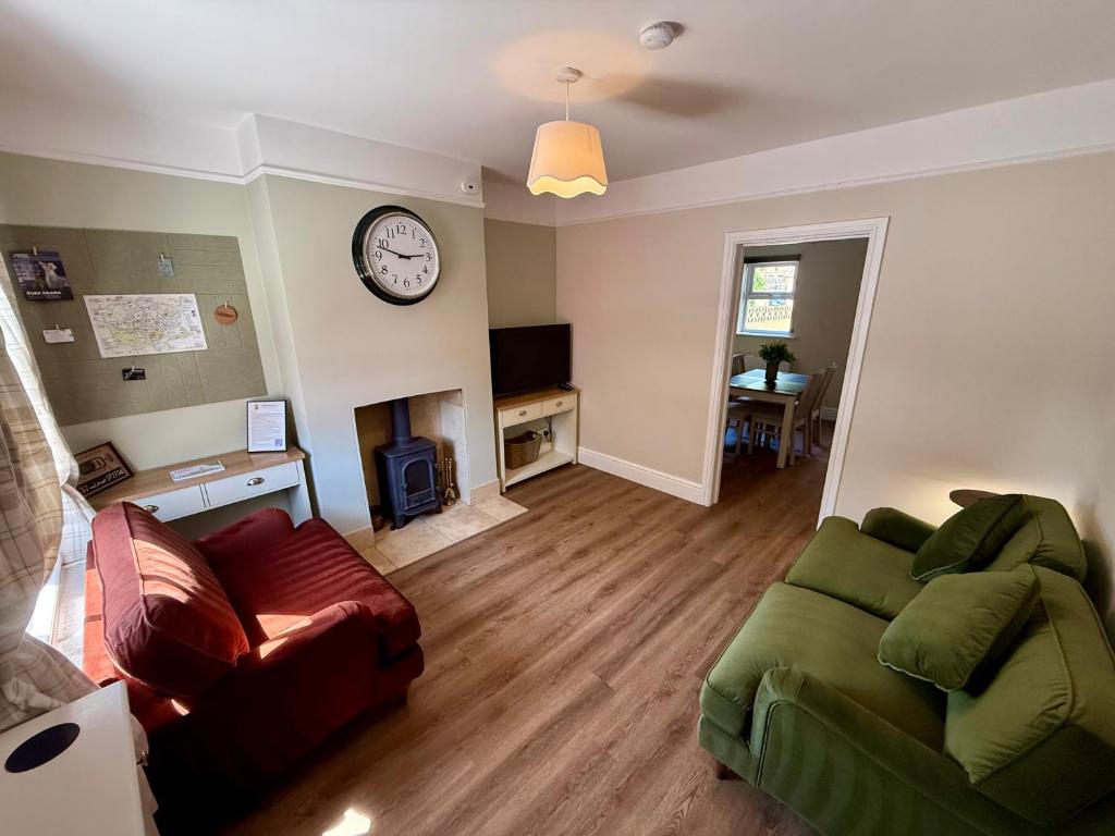 a living room with a couch and a clock on the wall at Salisbury City Centre Cottage in Salisbury