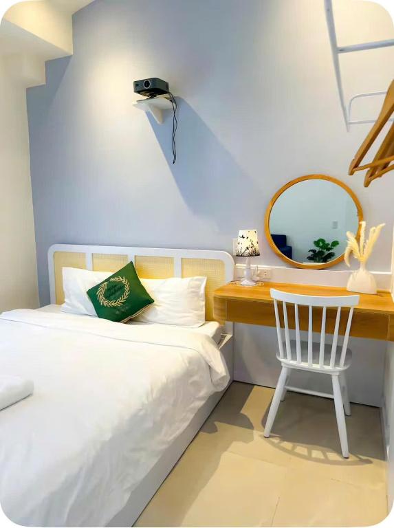 a bedroom with a bed and a desk with a mirror at Santo house in Thôn Trường Giang