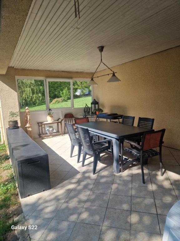 a patio with a table and chairs on a patio at Maison de campagne à Balaives et Butz in Flize