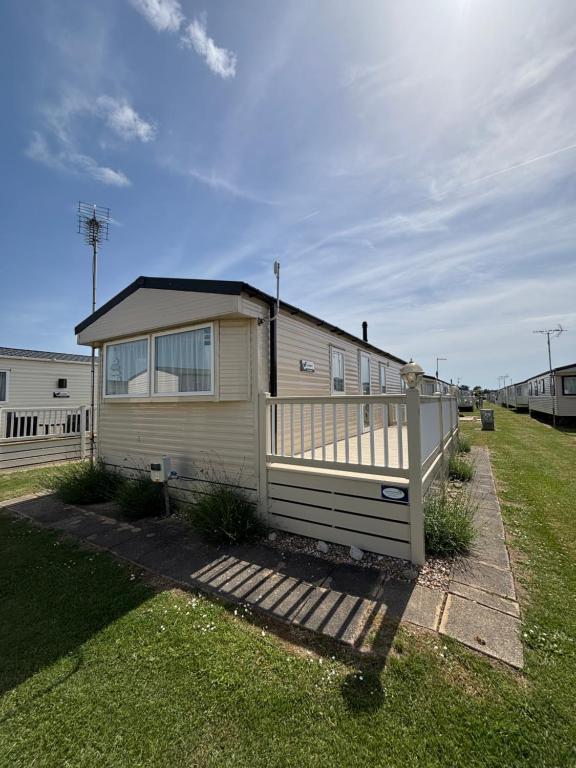a mobile home with a porch and a fence at Seaview Holiday Rentals - Etchingham in Chestfield