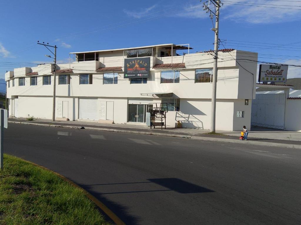 a white building on the side of a street at Alojamiento Sabadell Ibarra in Ibarra