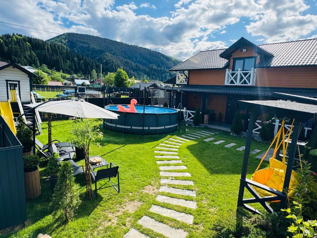 a backyard with a swimming pool and a house at Weekend house in Verkhovyna