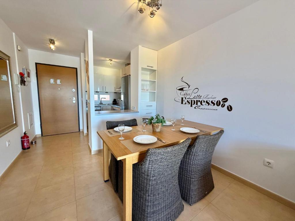 a dining room with a wooden table and chairs at Condado de Alhama la isla 7SV2D in El Romero