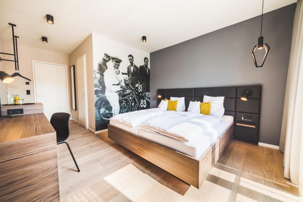 una camera con un grande letto e un dipinto sul muro di Hotel Garni Maximilian a Dingolfing