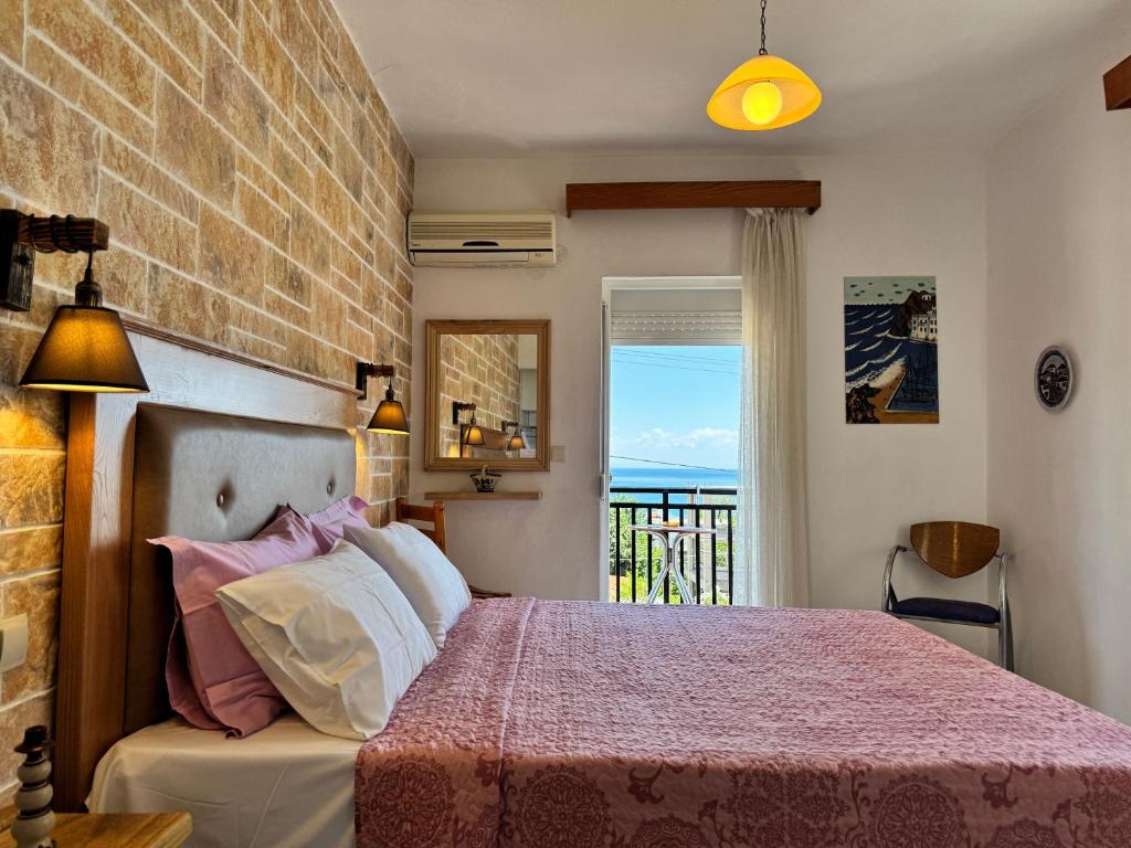 a bedroom with a bed and a view of the ocean at Studios Fedra in Potamiá