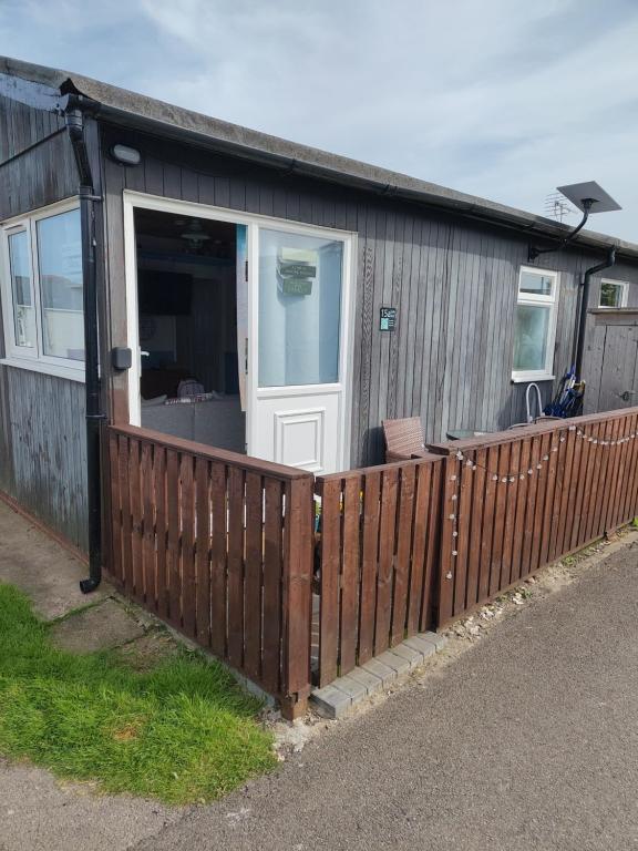 a house with a wooden fence and a white door at ElE G Holiday let's Bridlington in Bridlington