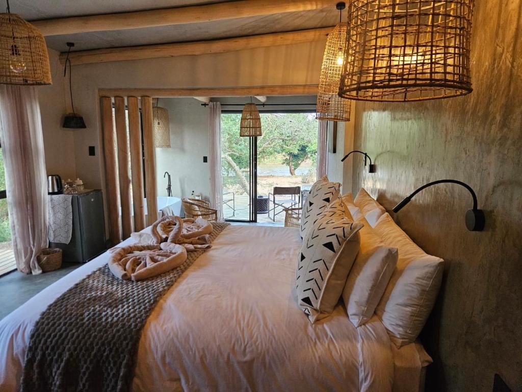 a bedroom with a large bed with pillows on it at Nkinga River Lodge in Balule Game Reserve