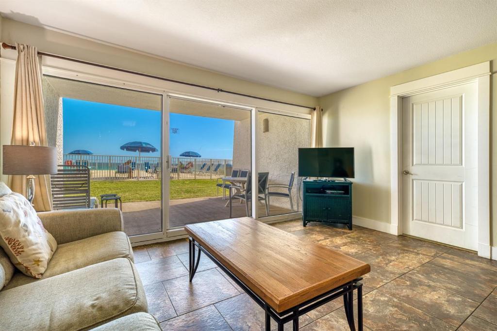 a living room with a couch and a table at Beach House Condominiums C103 - Beachfront with Pool, Wi-Fi, & Beach Service in Destin