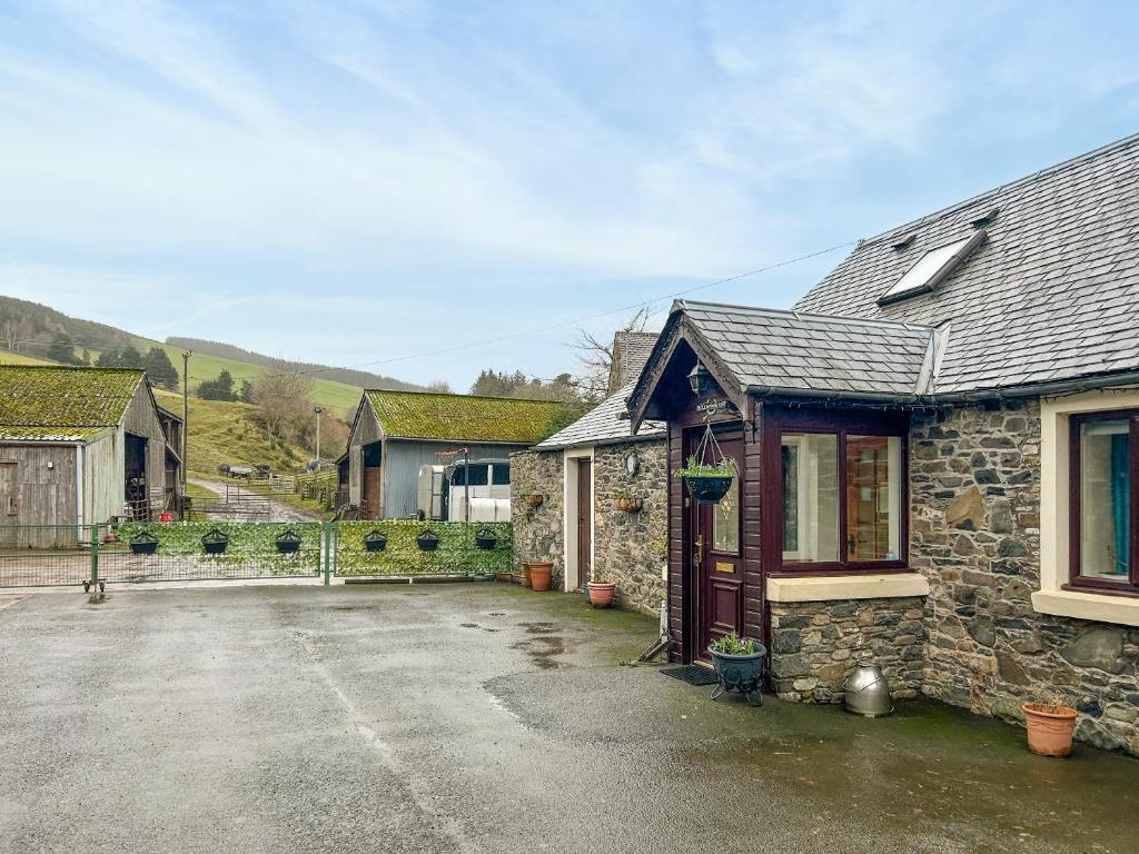 a stone house with a driveway in front of it at Ploughman's Rest - Uk51336 in Peebles