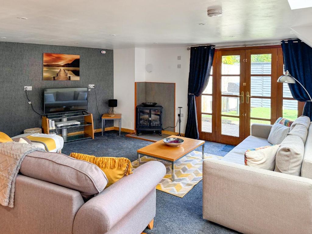 a living room with two couches and a television at The Spinney in Carterton