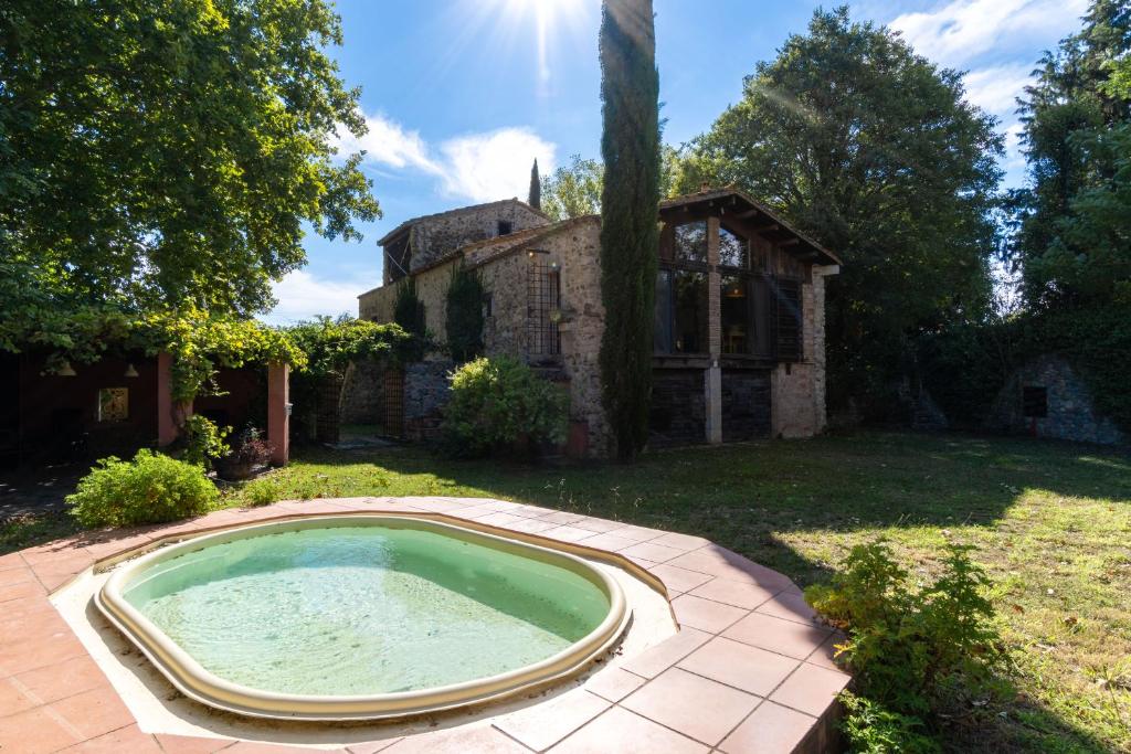 an outdoor swimming pool in the yard of a house at Can Cirili Rustic Romantic apartment for couples or family events in Bordils