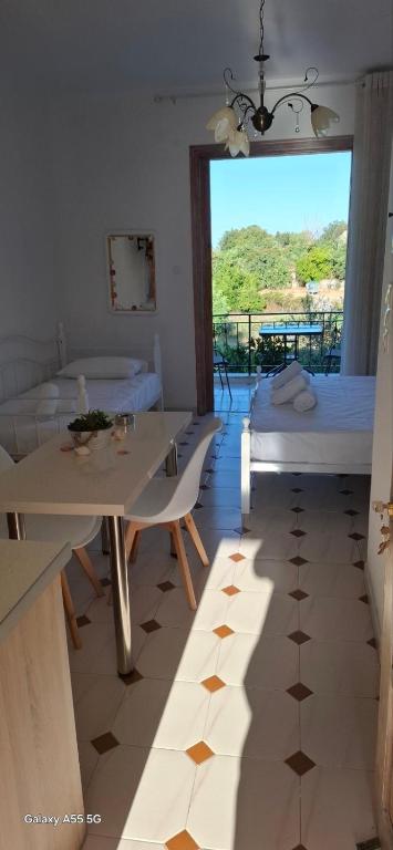 a room with a table and a bed and a window at Petros Studios in Nea Epidavros